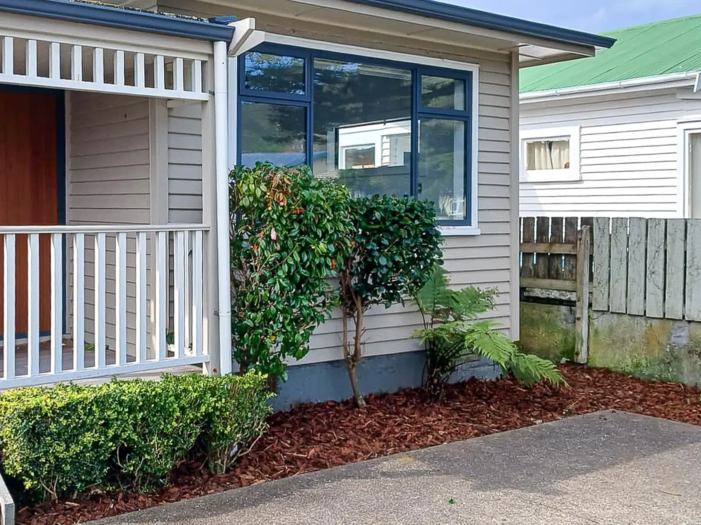 The same bed after the cleanup: weeded, shrubs shaped and freshly mulched